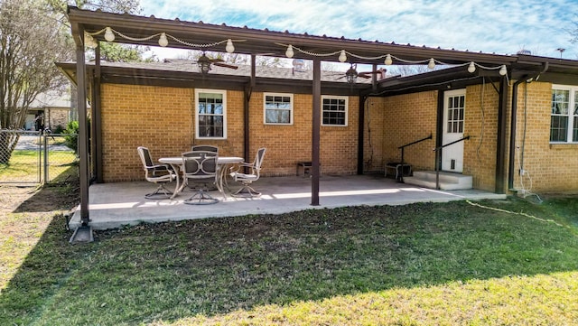 back of house with a patio area, brick siding, a lawn, and entry steps