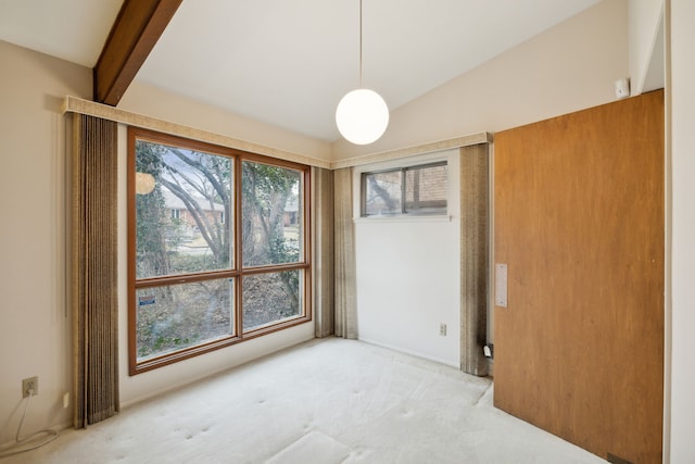 spare room featuring lofted ceiling and light carpet