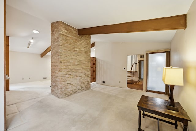 carpeted living room with stairway, brick wall, vaulted ceiling with beams, and visible vents