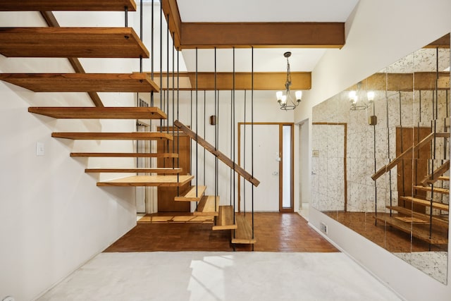 stairway featuring an inviting chandelier, visible vents, and beam ceiling