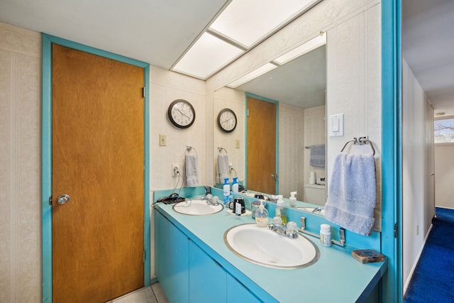 full bathroom with double vanity and a sink