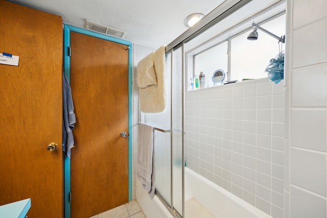 full bath with tile patterned floors, visible vents, and combined bath / shower with glass door