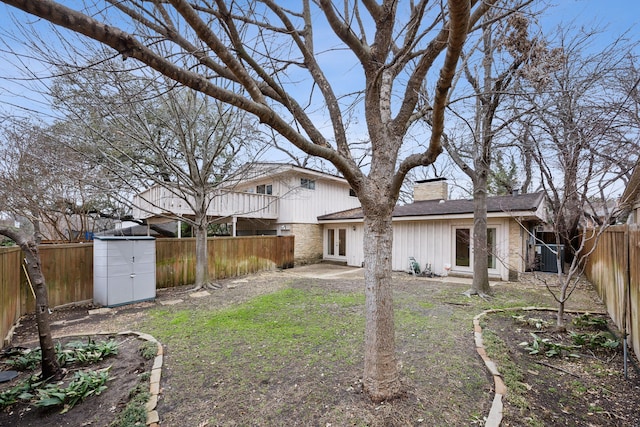 view of yard featuring a patio, an outbuilding, a fenced backyard, and a shed