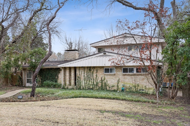 view of side of property with brick siding and a chimney