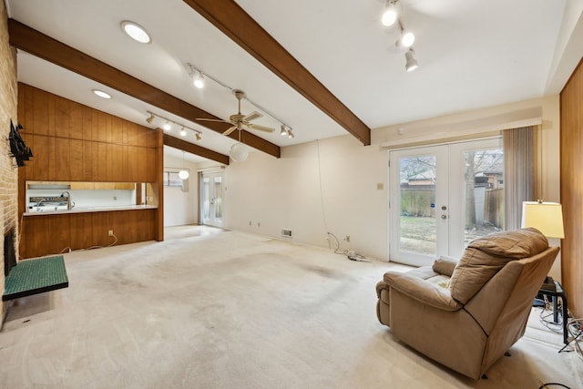 living area featuring light carpet, beamed ceiling, french doors, and visible vents