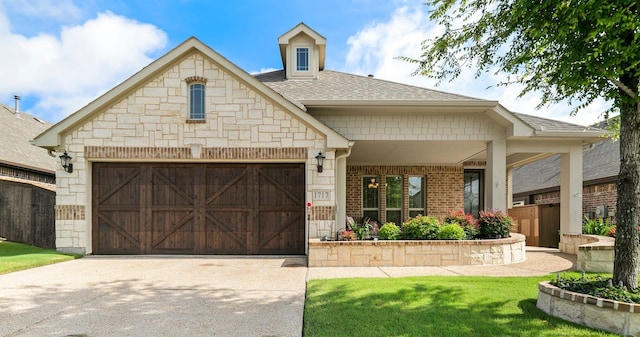 view of front of property with a garage, brick siding, driveway, stone siding, and roof with shingles