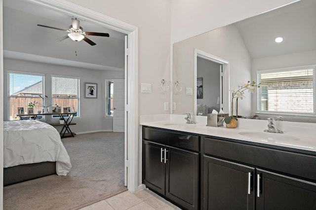 bathroom featuring lofted ceiling, tile patterned flooring, double vanity, and a sink