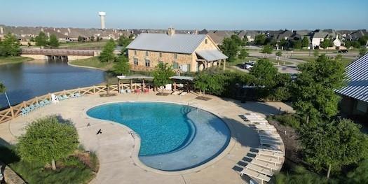 community pool featuring a water view and a patio