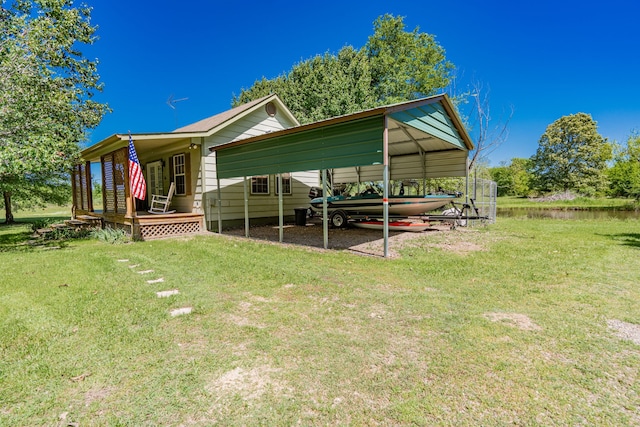 rear view of property featuring a carport and a yard