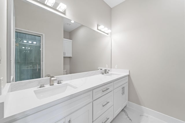 bathroom featuring marble finish floor, a sink, toilet, and a shower stall