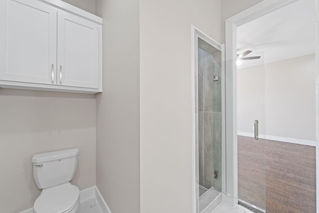 bathroom featuring ceiling fan, tiled shower, toilet, and baseboards