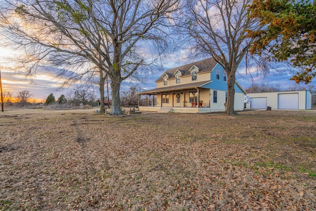 view of front of house featuring covered porch, an outbuilding, and a garage