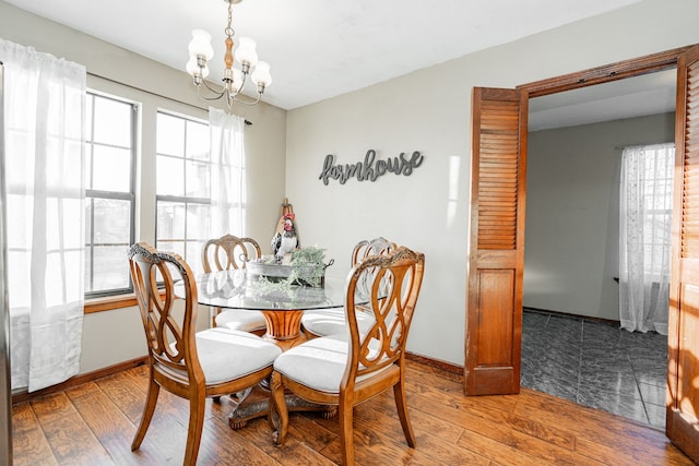 dining room with baseboards, hardwood / wood-style flooring, and an inviting chandelier