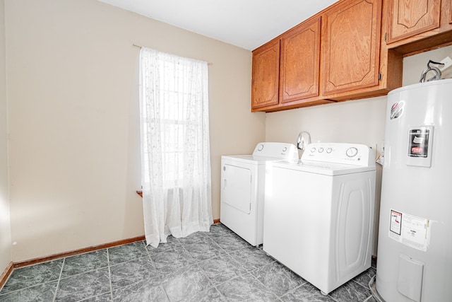 washroom with cabinet space, water heater, baseboards, and separate washer and dryer