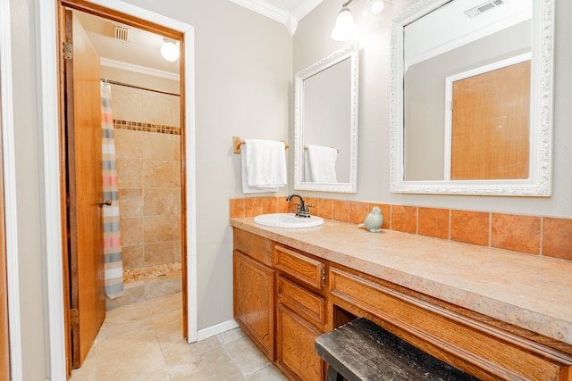 full bath with visible vents, tiled shower, crown molding, and vanity