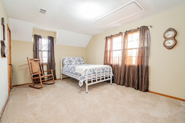 carpeted bedroom featuring vaulted ceiling, baseboards, visible vents, and attic access