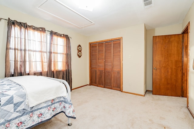 carpeted bedroom with attic access, a closet, visible vents, and baseboards