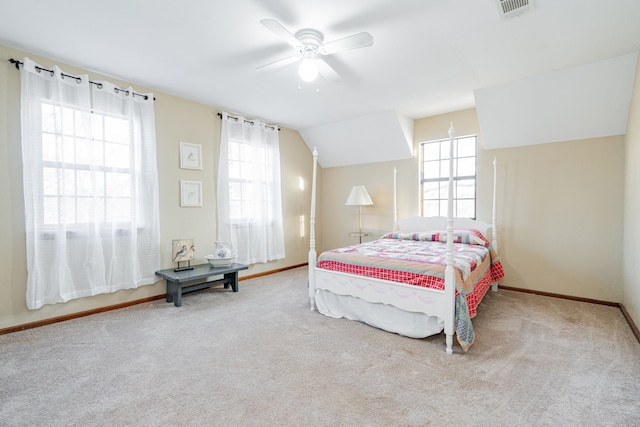 carpeted bedroom featuring baseboards, multiple windows, visible vents, and vaulted ceiling