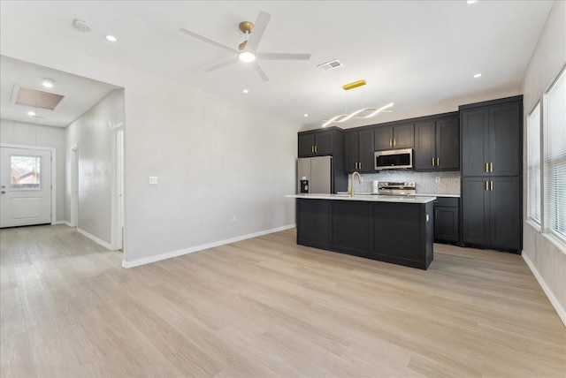 kitchen with light countertops, appliances with stainless steel finishes, visible vents, and light wood-style floors