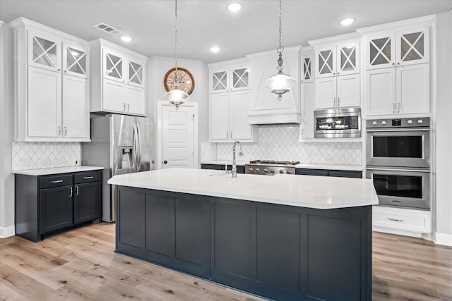 kitchen featuring stainless steel appliances, light countertops, visible vents, and white cabinetry