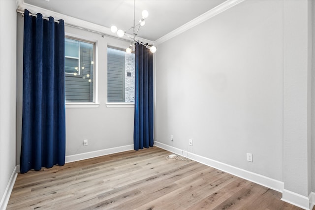 spare room featuring ornamental molding, wood finished floors, and baseboards