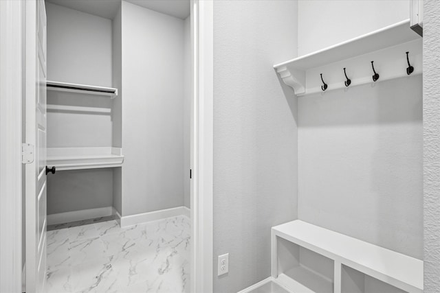 mudroom with marble finish floor and baseboards