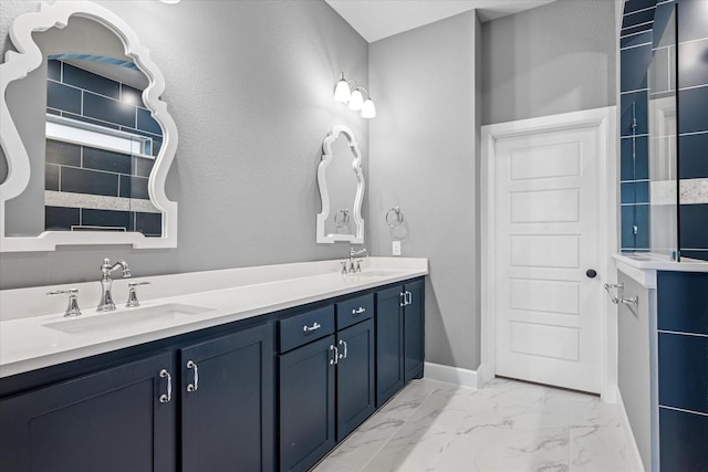 bathroom featuring marble finish floor, a sink, baseboards, and double vanity