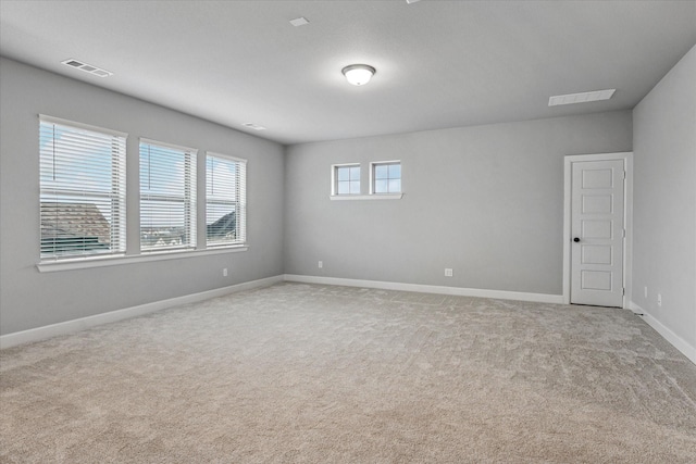 carpeted empty room with visible vents and baseboards