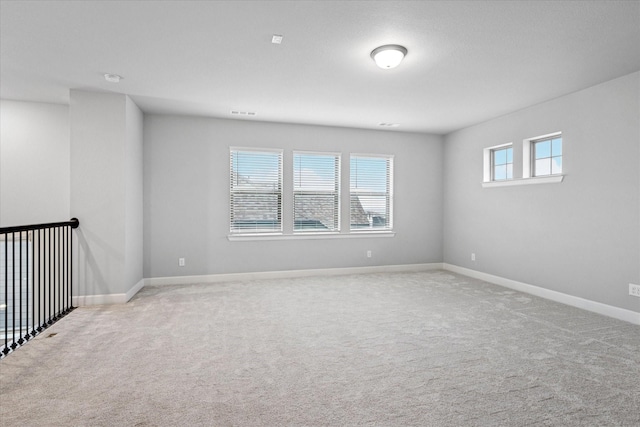 carpeted empty room featuring visible vents and baseboards