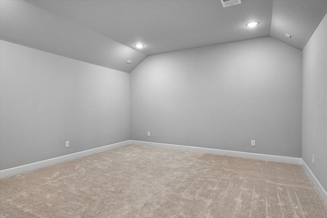 unfurnished room with carpet floors, lofted ceiling, and baseboards