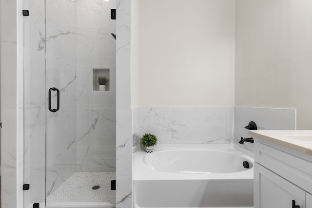 bathroom with a stall shower, vanity, and a bath