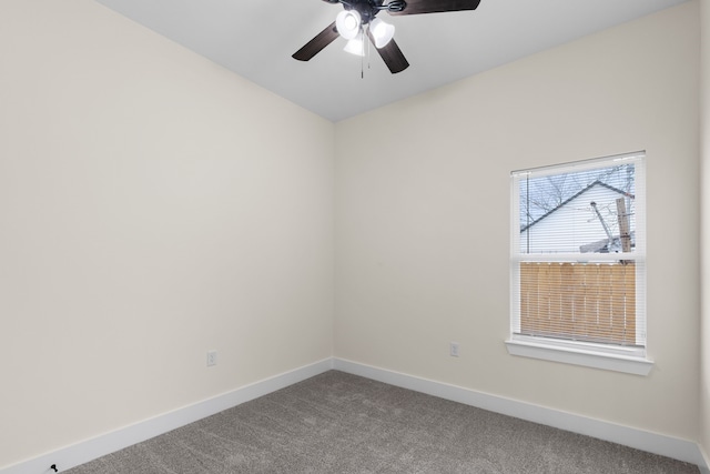 carpeted spare room with a ceiling fan and baseboards