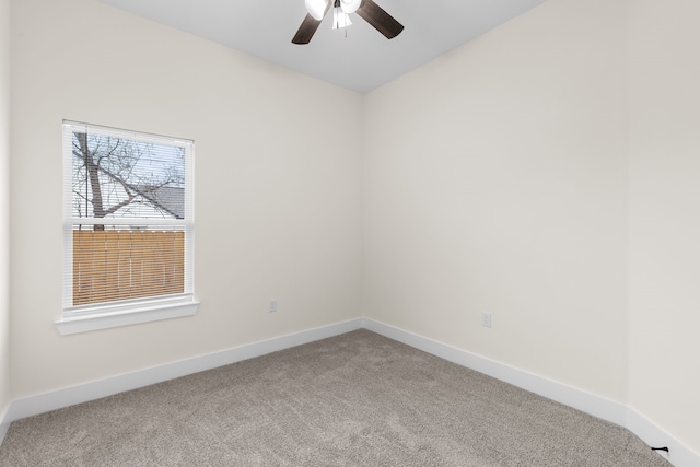 carpeted empty room featuring ceiling fan and baseboards