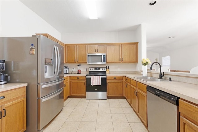 kitchen with appliances with stainless steel finishes, light countertops, and a sink