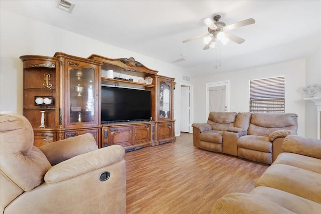 living area with light wood finished floors, ceiling fan, and visible vents