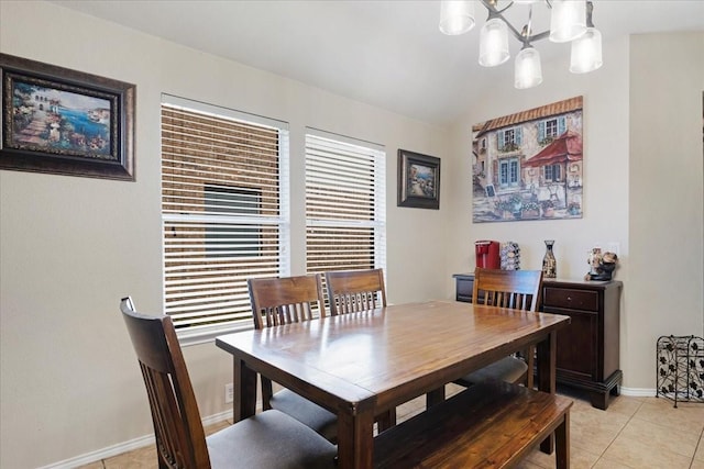 dining area with vaulted ceiling, light tile patterned flooring, baseboards, and an inviting chandelier