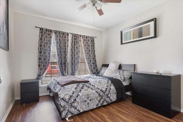 bedroom featuring a ceiling fan, baseboards, and wood finished floors