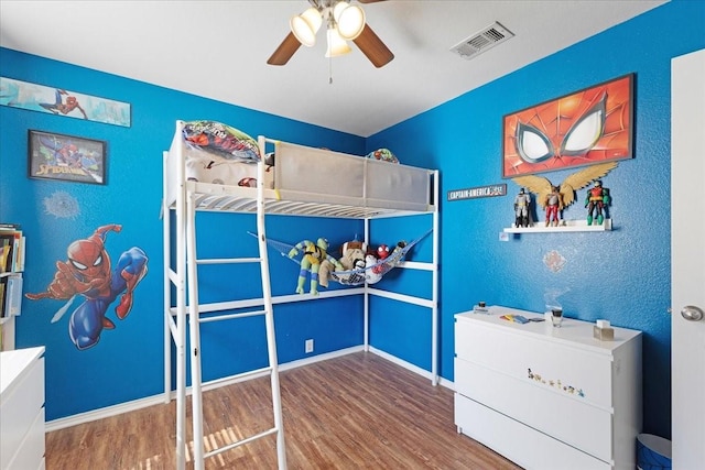 unfurnished bedroom featuring a ceiling fan, wood finished floors, visible vents, and baseboards