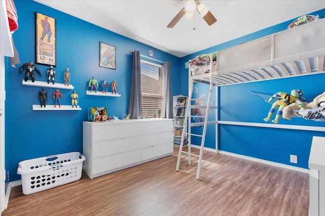 bedroom with ceiling fan, baseboards, and wood finished floors