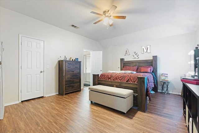 bedroom featuring light wood-type flooring, baseboards, visible vents, and lofted ceiling