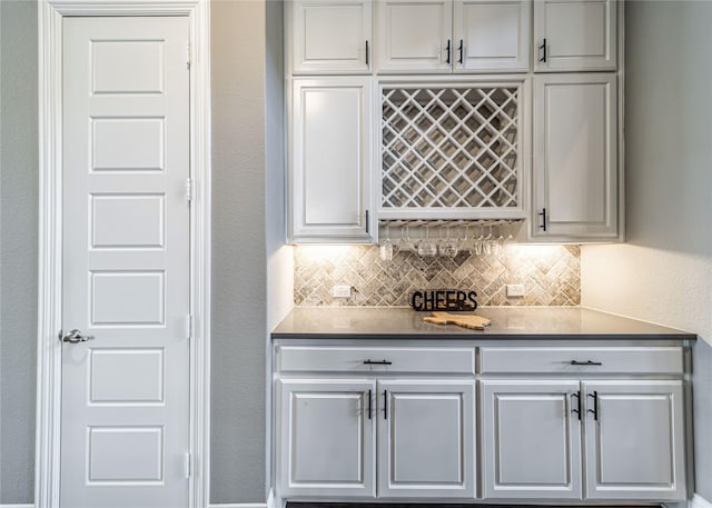 bar with a textured wall, a bar, and tasteful backsplash