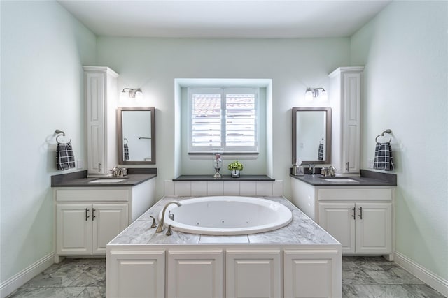 bathroom with marble finish floor, two vanities, and a sink