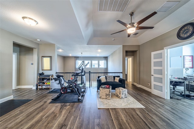 exercise area with wood finished floors, visible vents, and baseboards