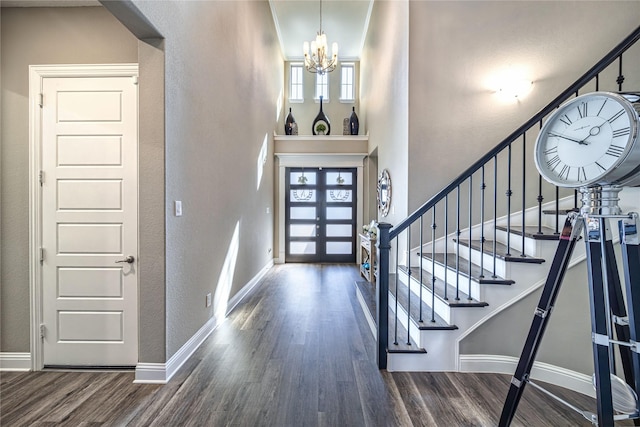 foyer with a chandelier, stairway, wood finished floors, and baseboards