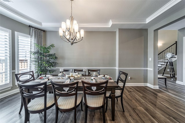 dining space with a notable chandelier, wood finished floors, baseboards, stairway, and crown molding