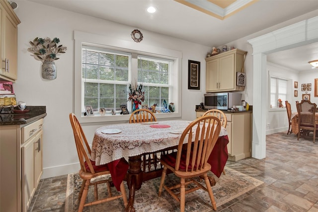 dining space featuring plenty of natural light, ornamental molding, baseboards, and stone finish flooring