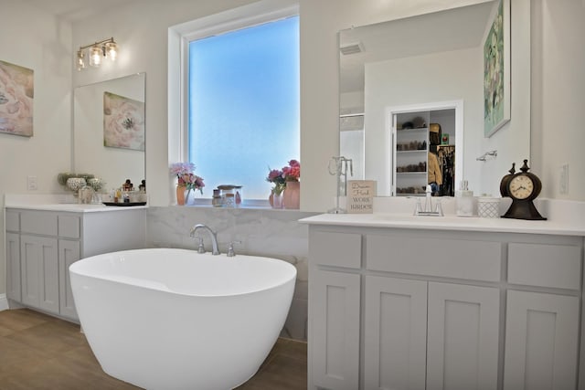 bathroom with vanity, visible vents, a freestanding bath, a spacious closet, and a shower stall