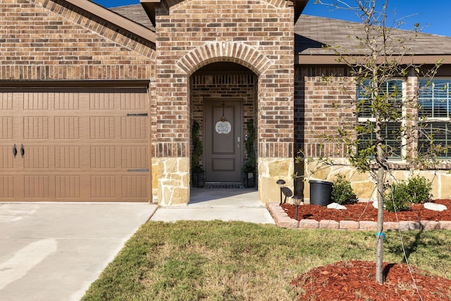 property entrance featuring concrete driveway and brick siding