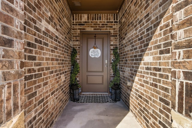 doorway to property with brick siding