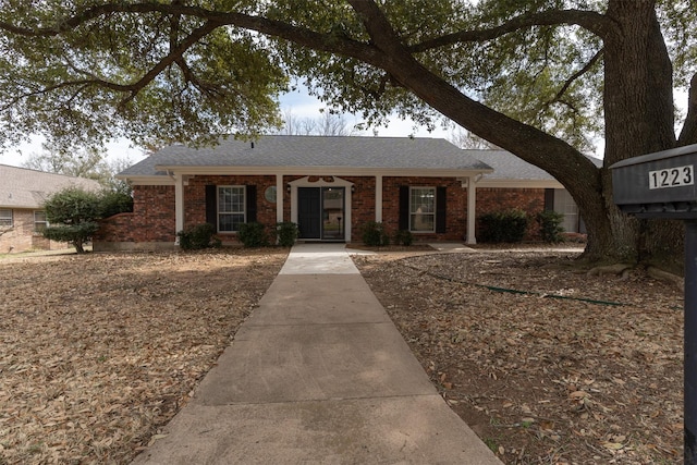 ranch-style house with a shingled roof and brick siding